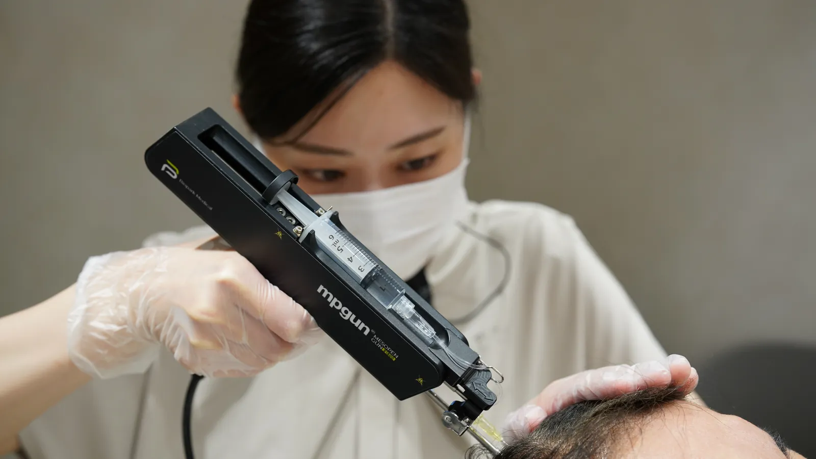 機器のハンドピースを構える看護師